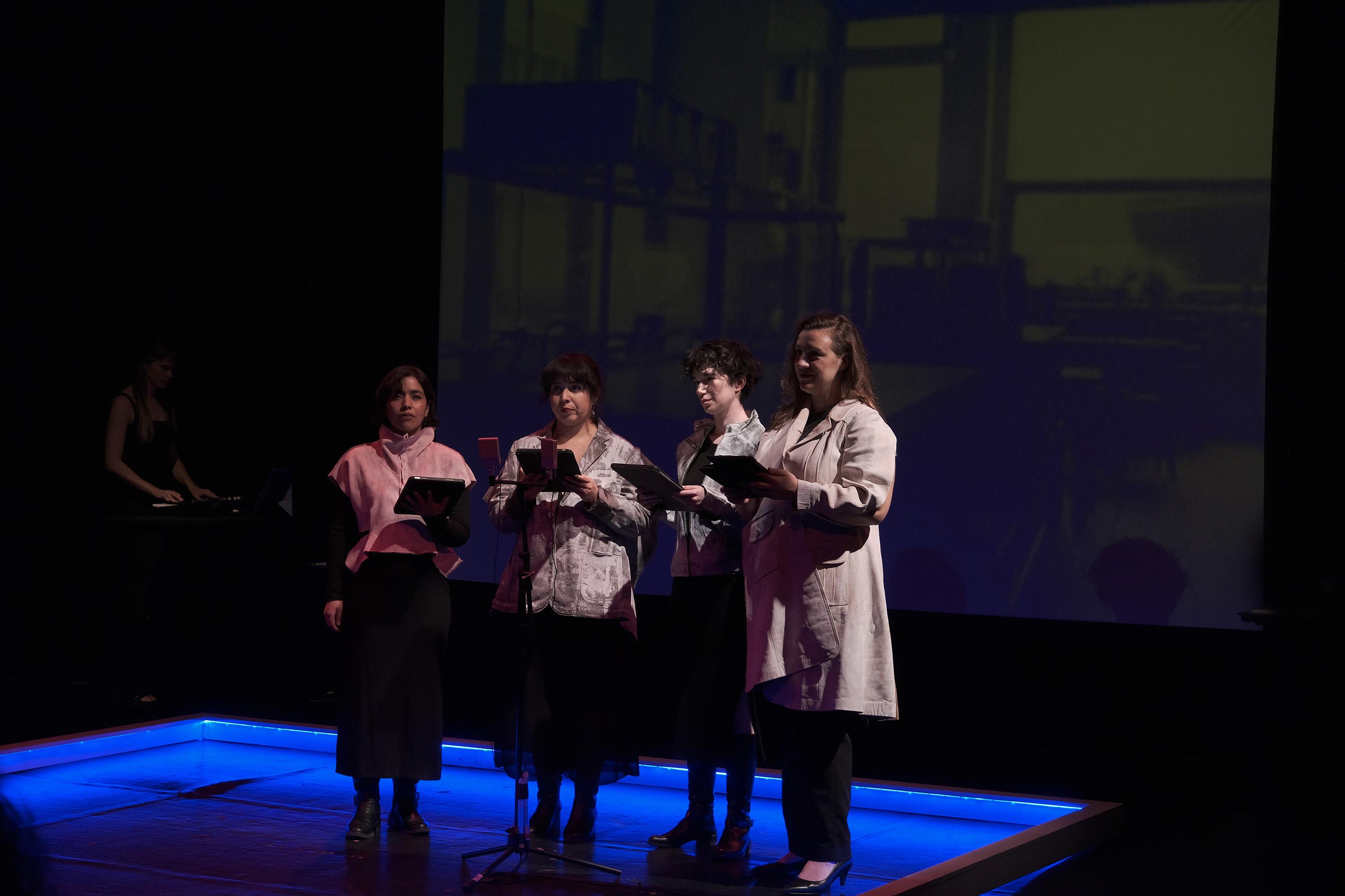 Vocal ensemble performing with tablets and projection.